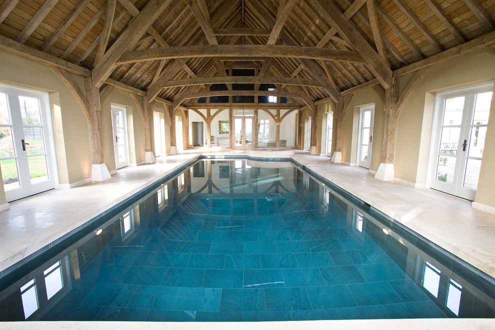 Exempel på en modern inomhus, rektangulär pool, med naturstensplattor
