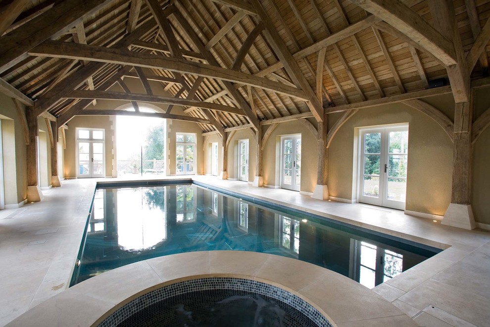 Imagen de piscina contemporánea interior y rectangular con adoquines de piedra natural