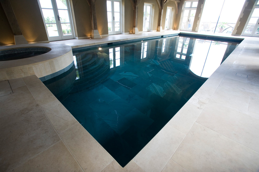 Ispirazione per una piscina coperta design rettangolare con pavimentazioni in pietra naturale