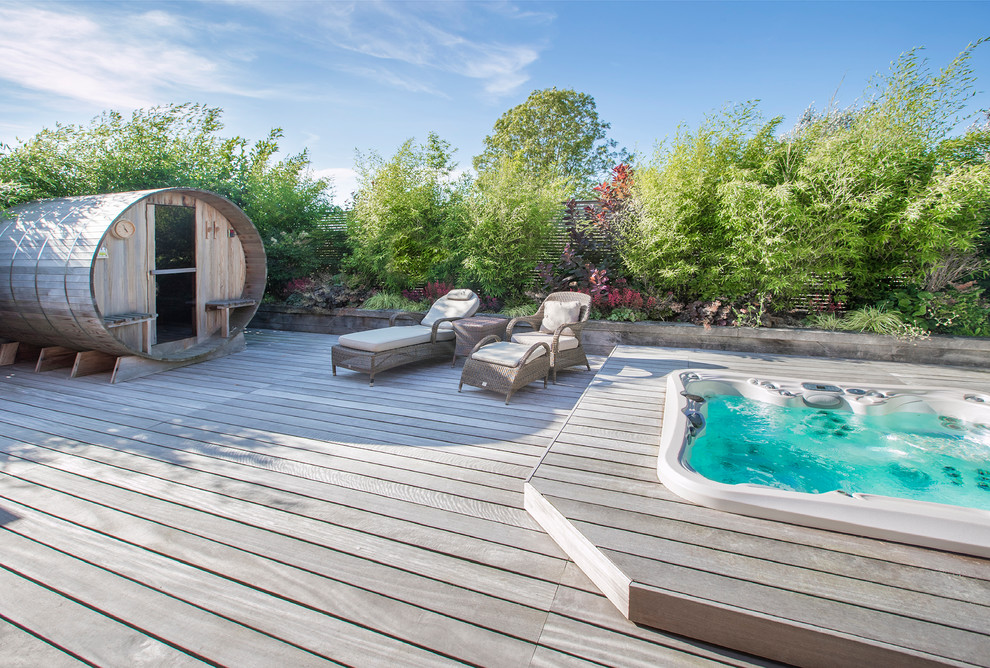 Exemple d'une piscine hors-sol et latérale tendance de taille moyenne et rectangle avec un bain bouillonnant et une terrasse en bois.