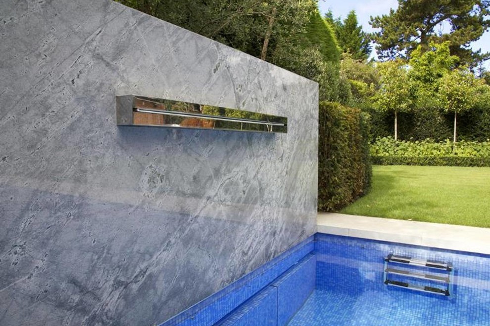 Diseño de piscina contemporánea rectangular en patio trasero con suelo de baldosas
