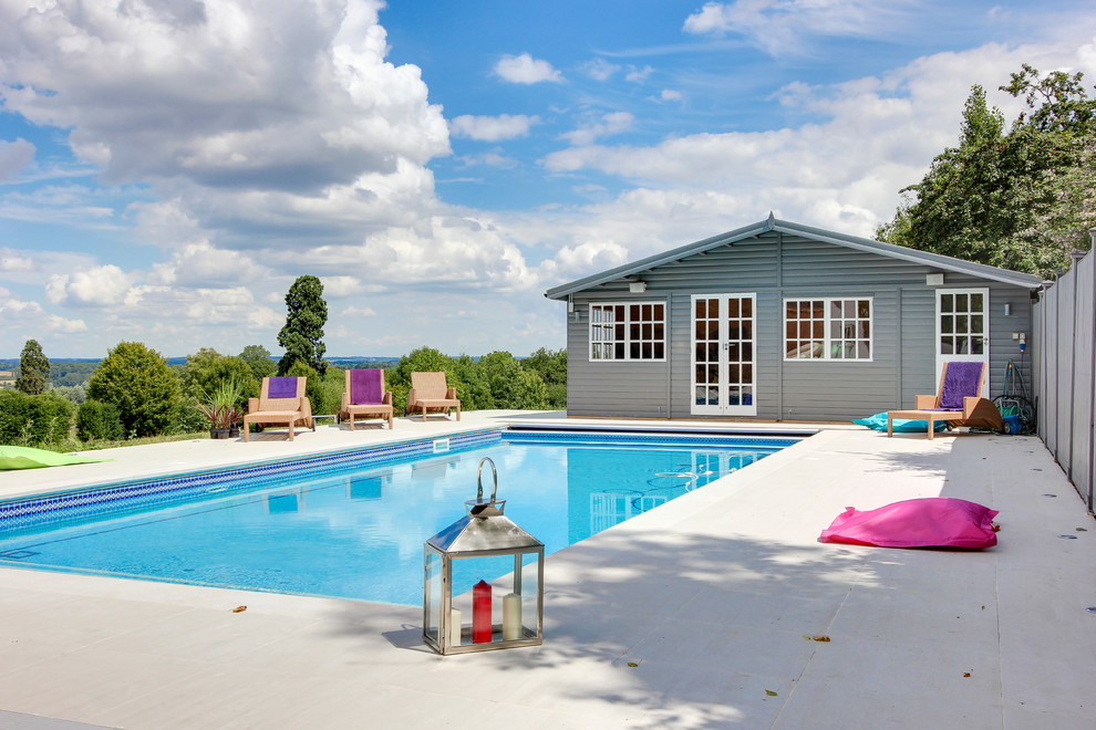 Pool - traditional backyard rectangular and tile lap pool idea in London
