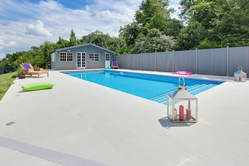 Immagine di una piscina contemporanea dietro casa con piastrelle