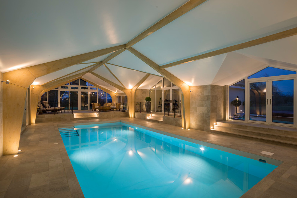 Idee per un'ampia piscina coperta contemporanea rettangolare con pavimentazioni in pietra naturale