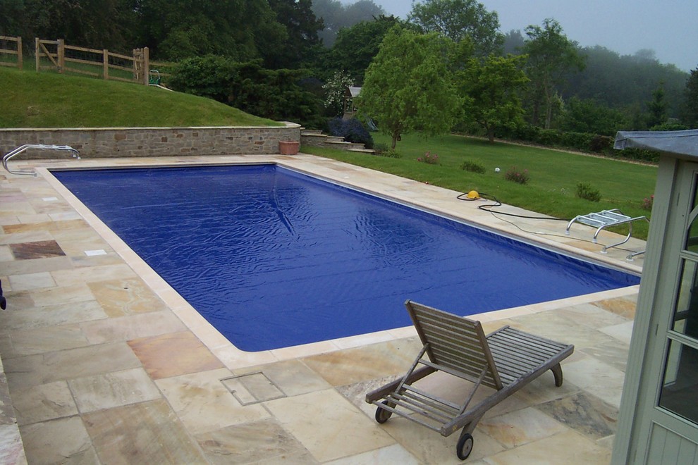 Пример оригинального дизайна: большой спортивный, прямоугольный бассейн на заднем дворе в стиле кантри с домиком у бассейна и покрытием из каменной брусчатки
