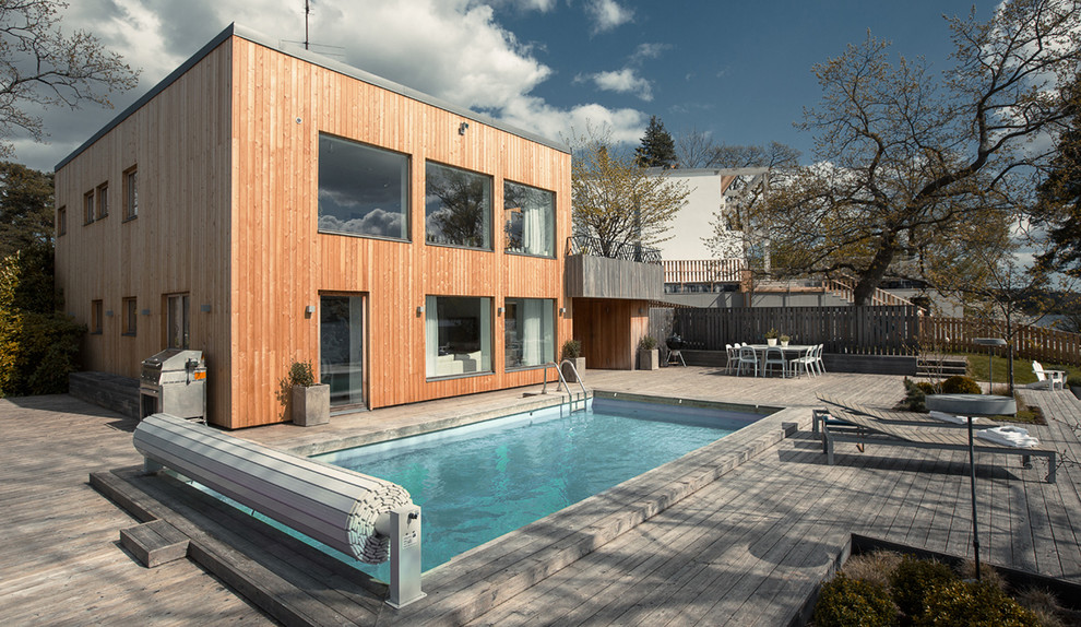 Exemple d'une piscine scandinave rectangle avec une terrasse en bois.