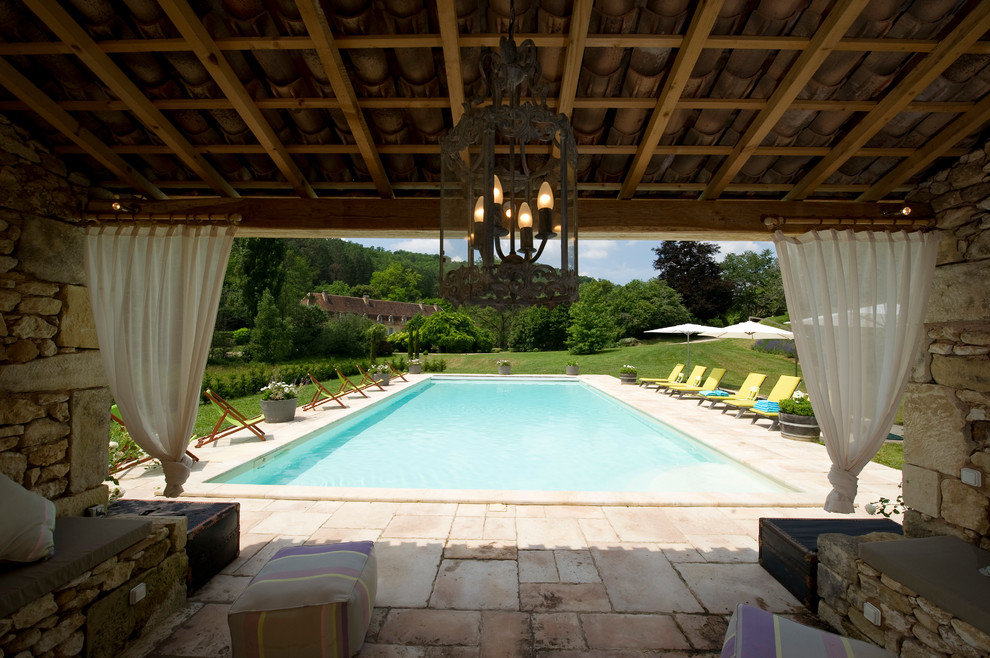 На фото: прямоугольный бассейн в средиземноморском стиле с домиком у бассейна с