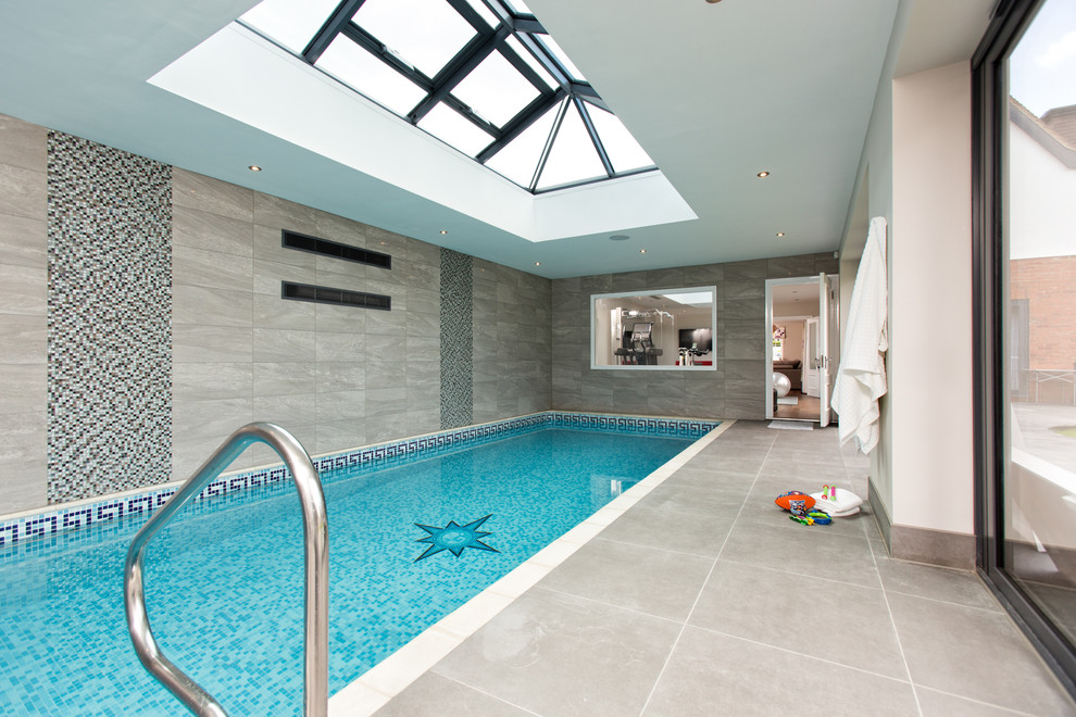 Design ideas for a contemporary indoor rectangular swimming pool in Berkshire with a pool house and tiled flooring.