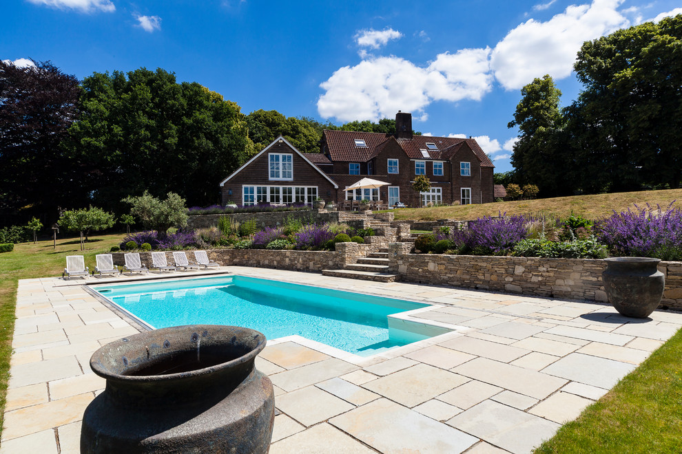 Mid-sized elegant backyard stone and rectangular pool photo in Sussex