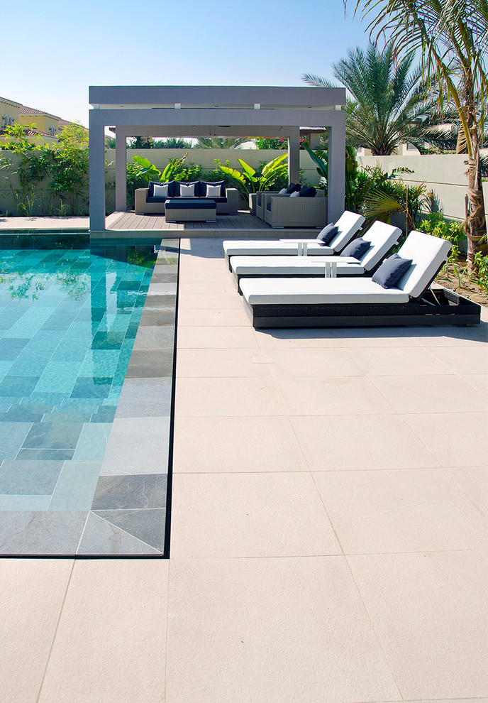 Aménagement d'une grande piscine à débordement et arrière contemporaine rectangle avec un point d'eau et du carrelage.