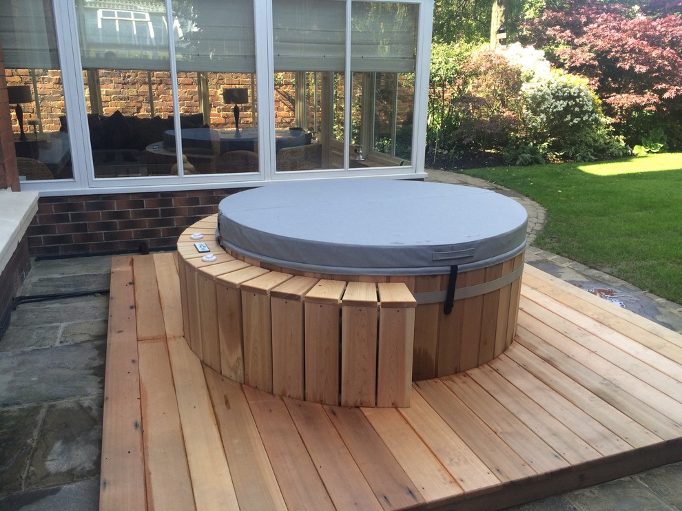 Пример оригинального дизайна: круглый бассейн среднего размера на заднем дворе в стиле рустика с настилом