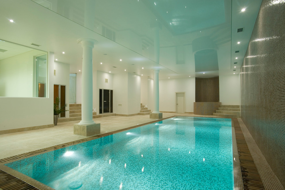 Idée de décoration pour une grande piscine intérieure rectangle avec un bain bouillonnant.