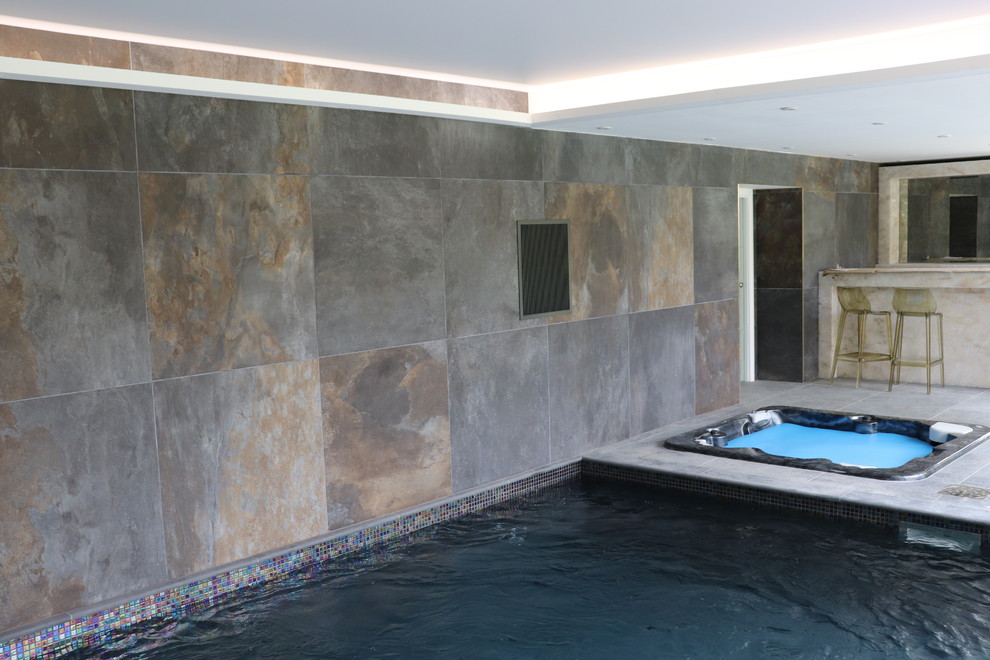 Modelo de casa de la piscina y piscina elevada contemporánea de tamaño medio rectangular en patio trasero con granito descompuesto