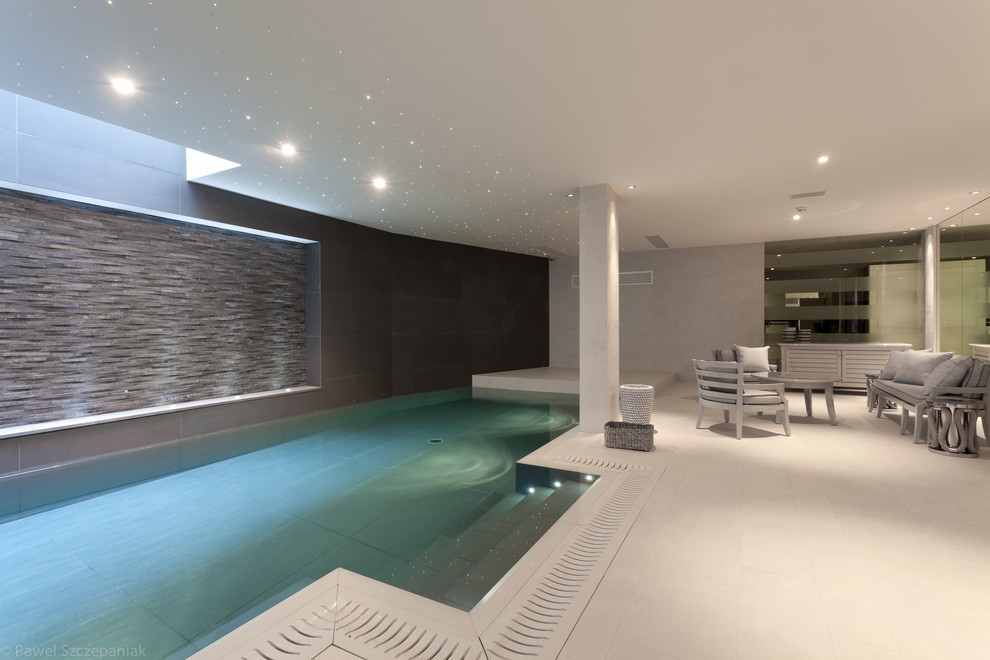 Réalisation d'une piscine intérieure minimaliste de taille moyenne et rectangle.