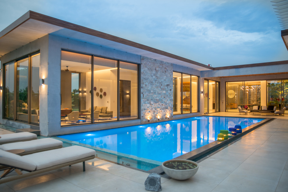 Diseño de piscina minimalista grande rectangular en patio con suelo de baldosas