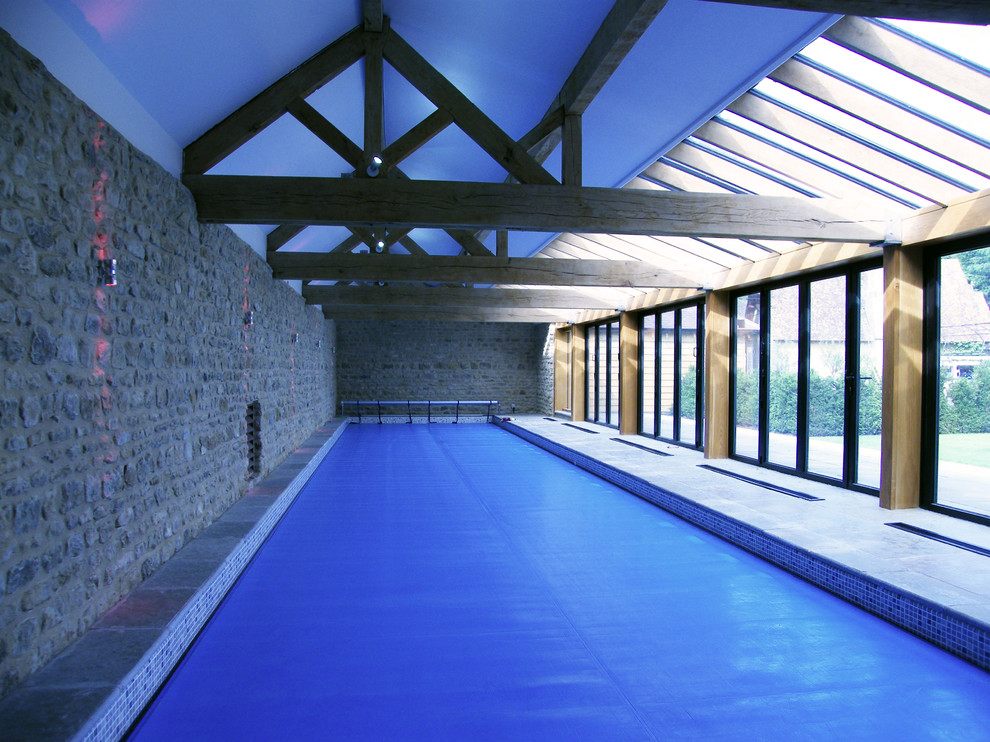 Exemple d'une piscine nature de taille moyenne et rectangle avec des pavés en pierre naturelle.