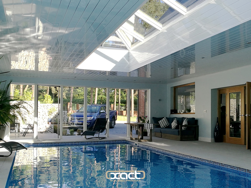 Example of a large trendy indoor tile and rectangular lap pool design in Surrey