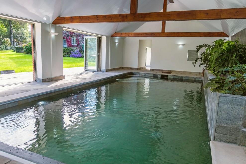 Foto de casa de la piscina y piscina alargada contemporánea grande rectangular en patio trasero con adoquines de piedra natural
