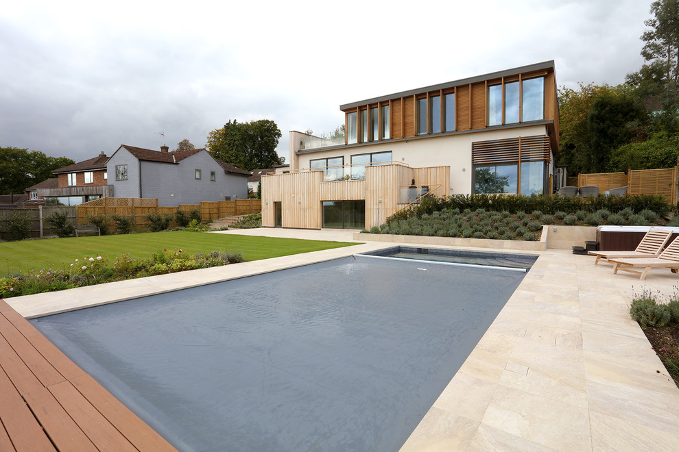Imagen de piscina elevada actual grande rectangular en patio trasero con suelo de baldosas