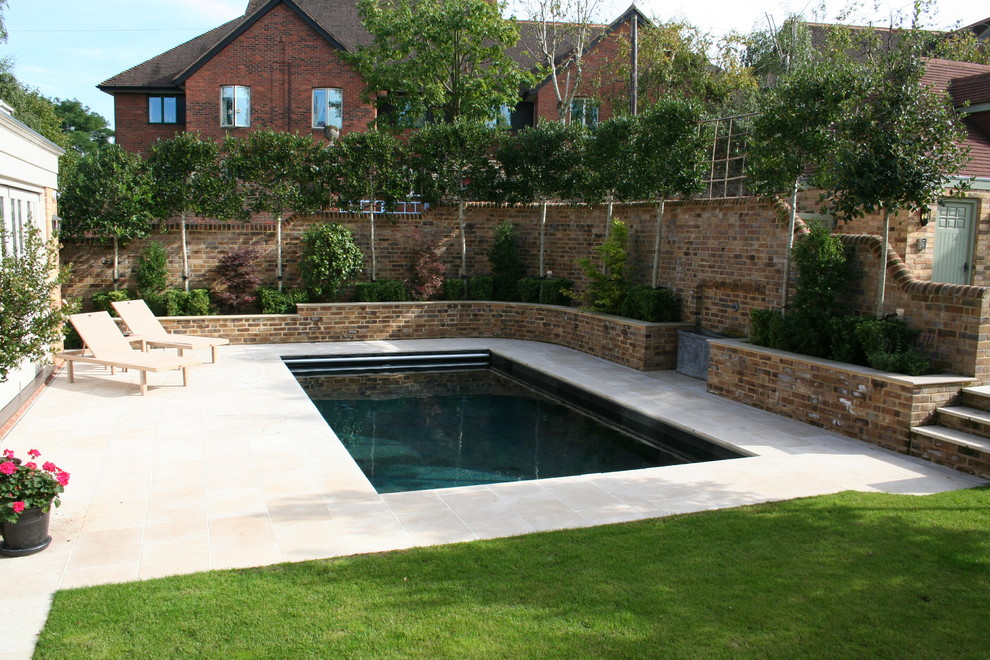 Diseño de piscina tradicional de tamaño medio rectangular en patio trasero con suelo de baldosas