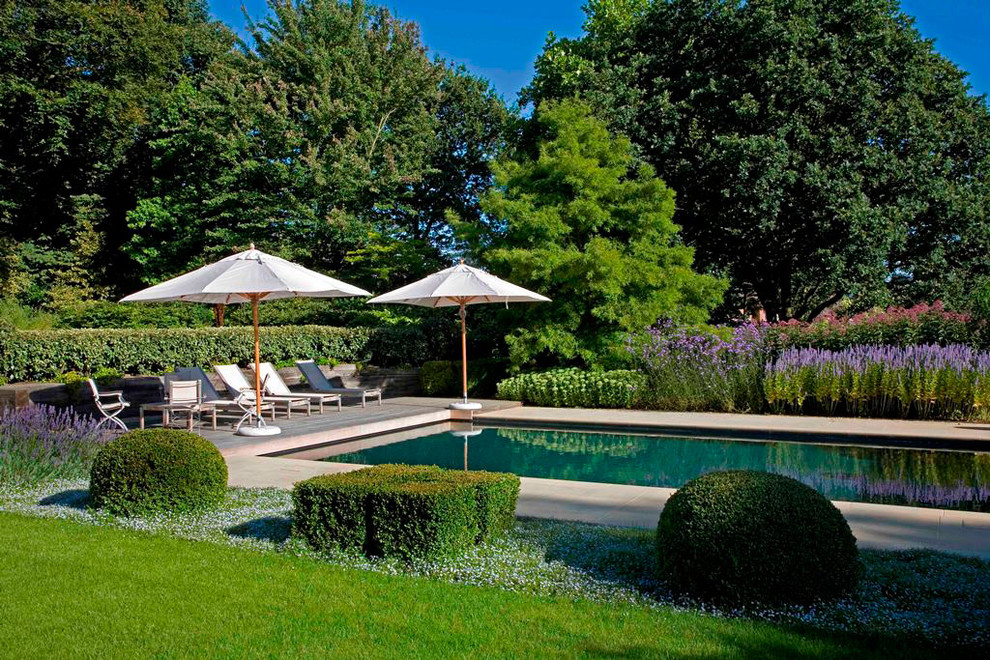 Foto de piscina campestre de tamaño medio rectangular en patio trasero con adoquines de piedra natural