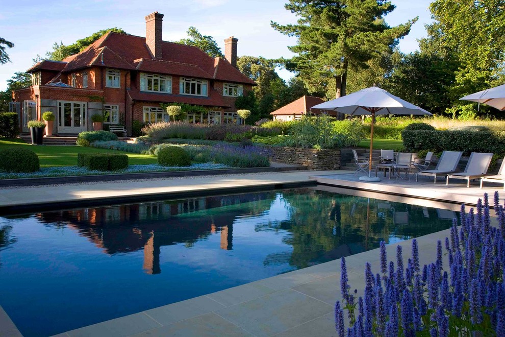 Inspiration for a medium sized country back rectangular swimming pool in Sussex with natural stone paving.
