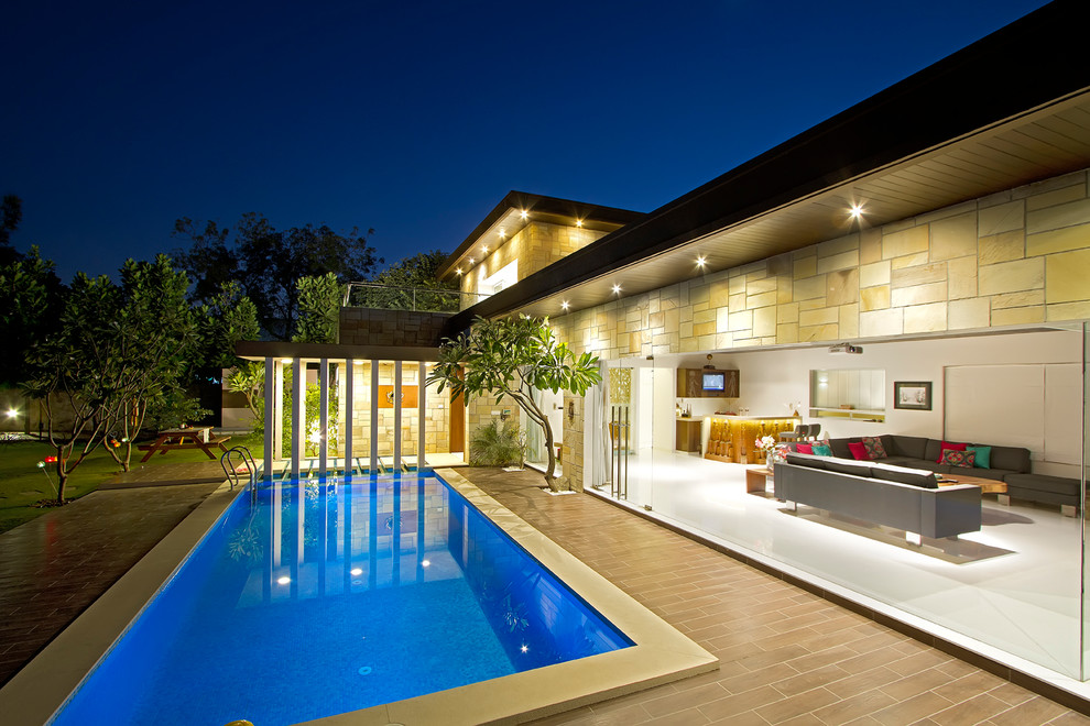 Imagen de piscina alargada contemporánea grande rectangular con suelo de baldosas