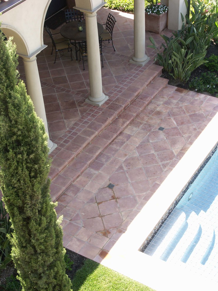 Foto de piscina mediterránea en patio con suelo de baldosas