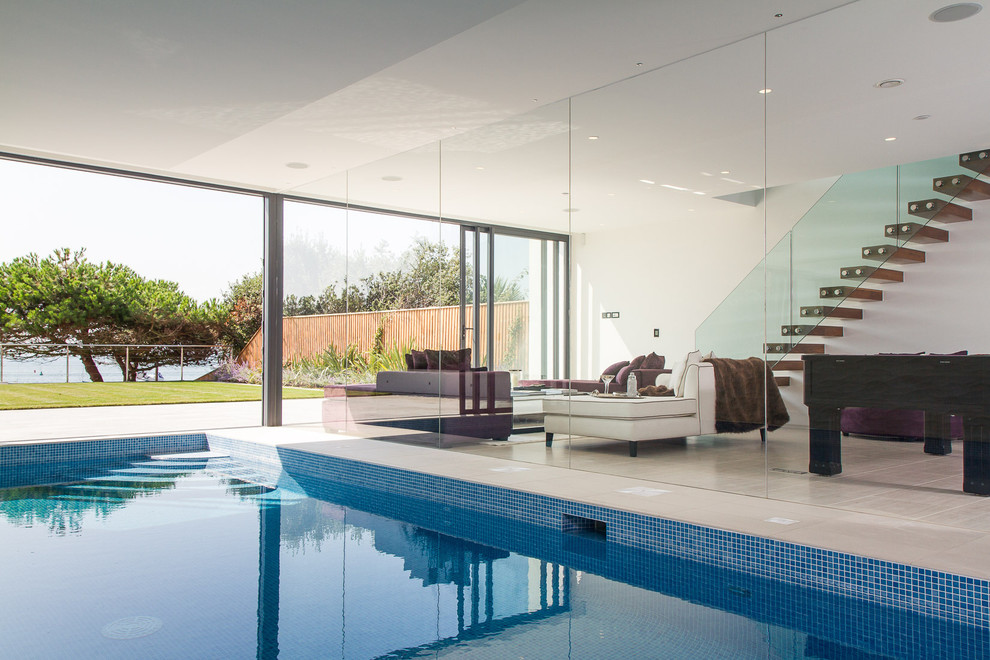 Пример оригинального дизайна: прямоугольный бассейн в доме в современном стиле с покрытием из плитки