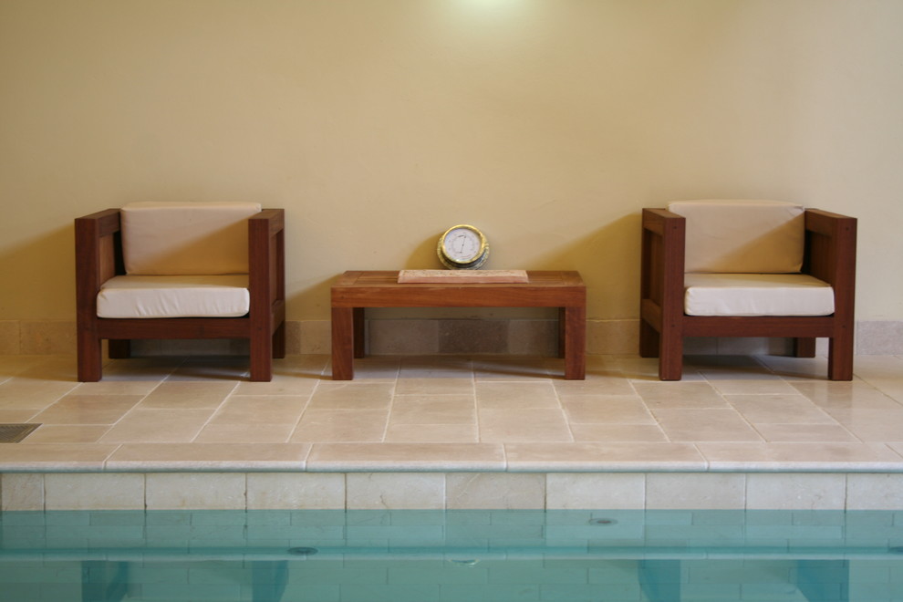 Ispirazione per una grande piscina coperta tradizionale rettangolare con una dépendance a bordo piscina e pavimentazioni in pietra naturale