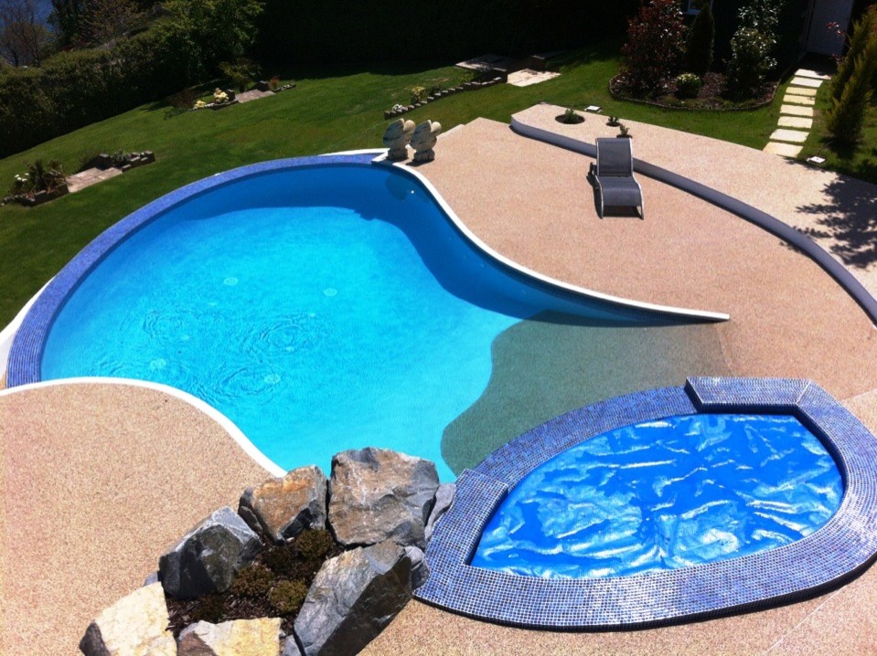 Immagine di una grande piscina fuori terra moderna personalizzata dietro casa con ghiaia