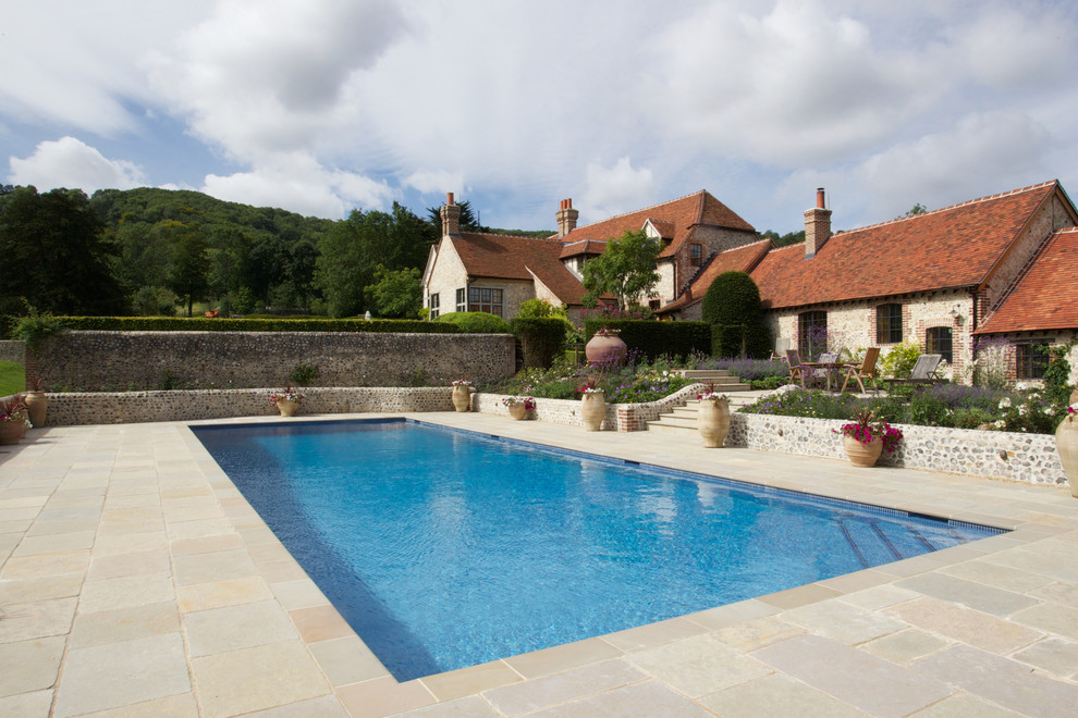 Diseño de piscina infinita de estilo de casa de campo rectangular en patio lateral