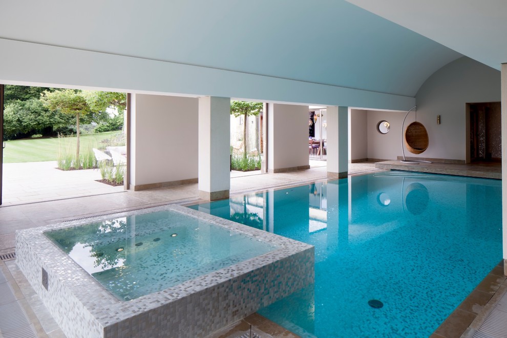 На фото: прямоугольный бассейн в доме в стиле неоклассика (современная классика) с джакузи