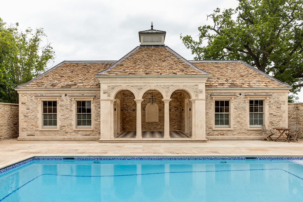 Ejemplo de casa de la piscina y piscina clásica rectangular con adoquines de piedra natural