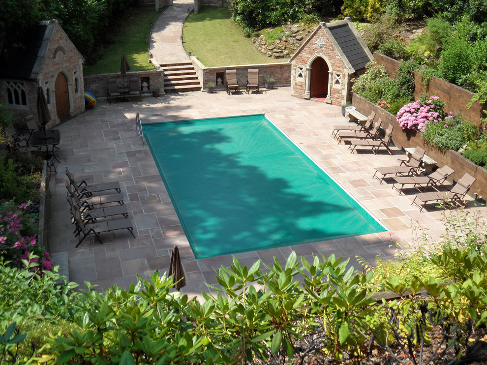Idee per una piscina rustica rettangolare dietro casa con pavimentazioni in pietra naturale