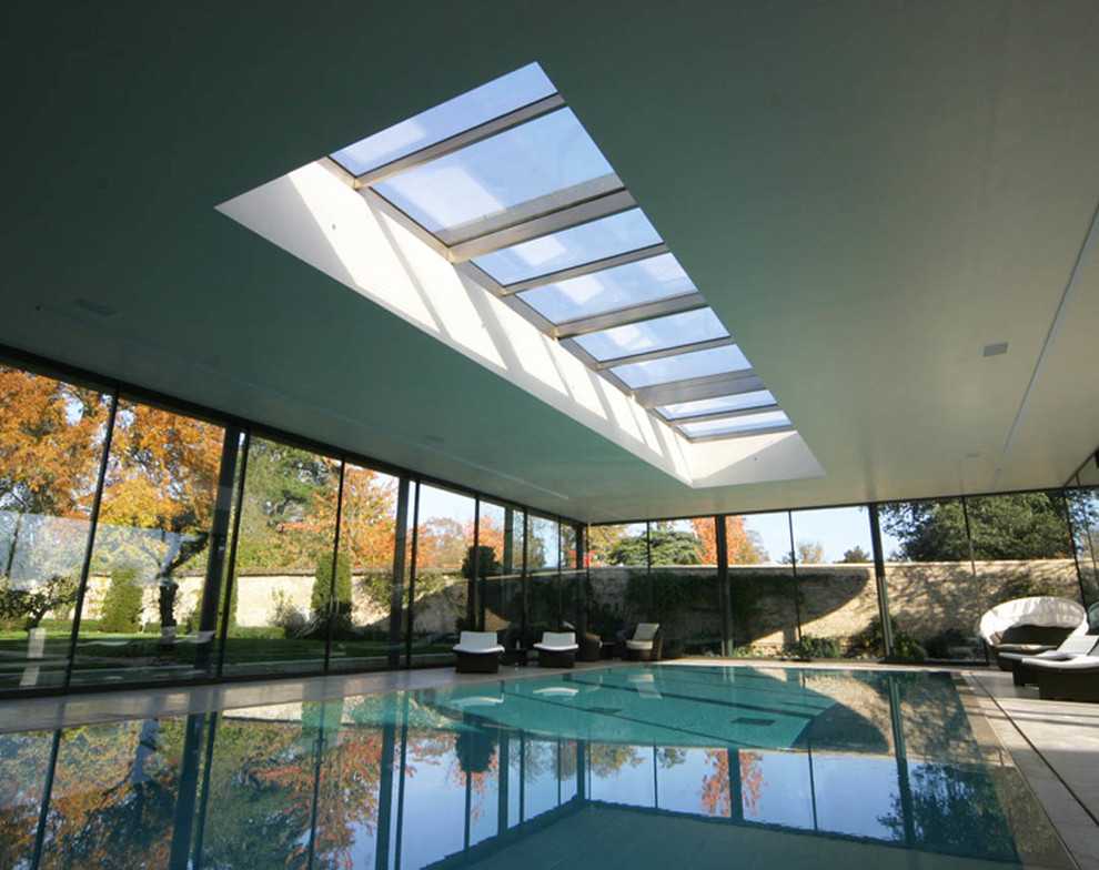 Inspiration for a large contemporary swimming pool in London with a pool house.