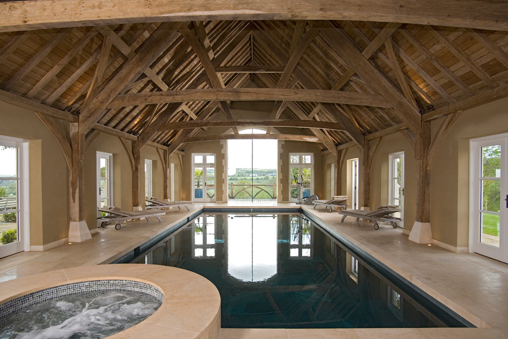 Inspiration for a rustic indoor rectangular swimming pool in West Midlands with a pool house, a shelter and natural stone paving.