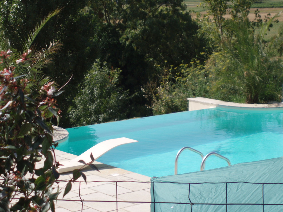 Idée de décoration pour une piscine sur toit à débordement méditerranéenne de taille moyenne et rectangle avec un point d'eau et des pavés en pierre naturelle.