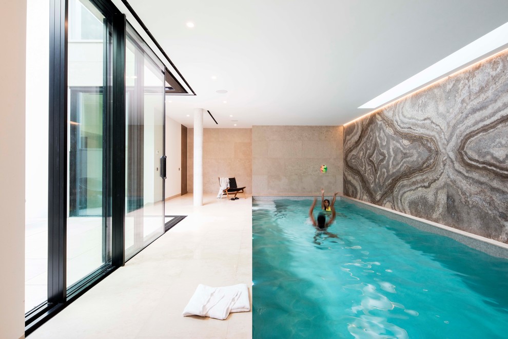 Contemporary indoor rectangular swimming pool in London with tiled flooring.