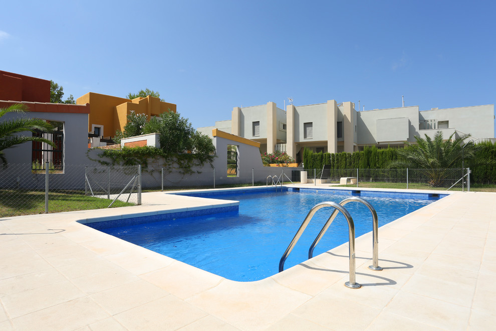 Esempio di una piccola piscina mediterranea a "L" dietro casa con fontane e lastre di cemento