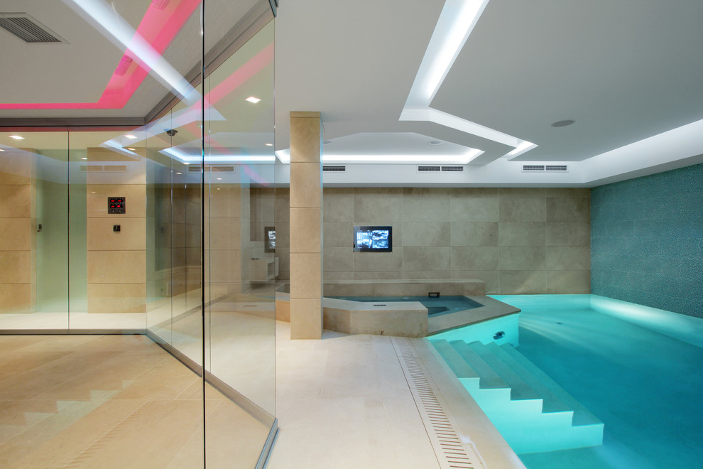 Photo of an expansive contemporary indoor custom shaped swimming pool with a pool house.