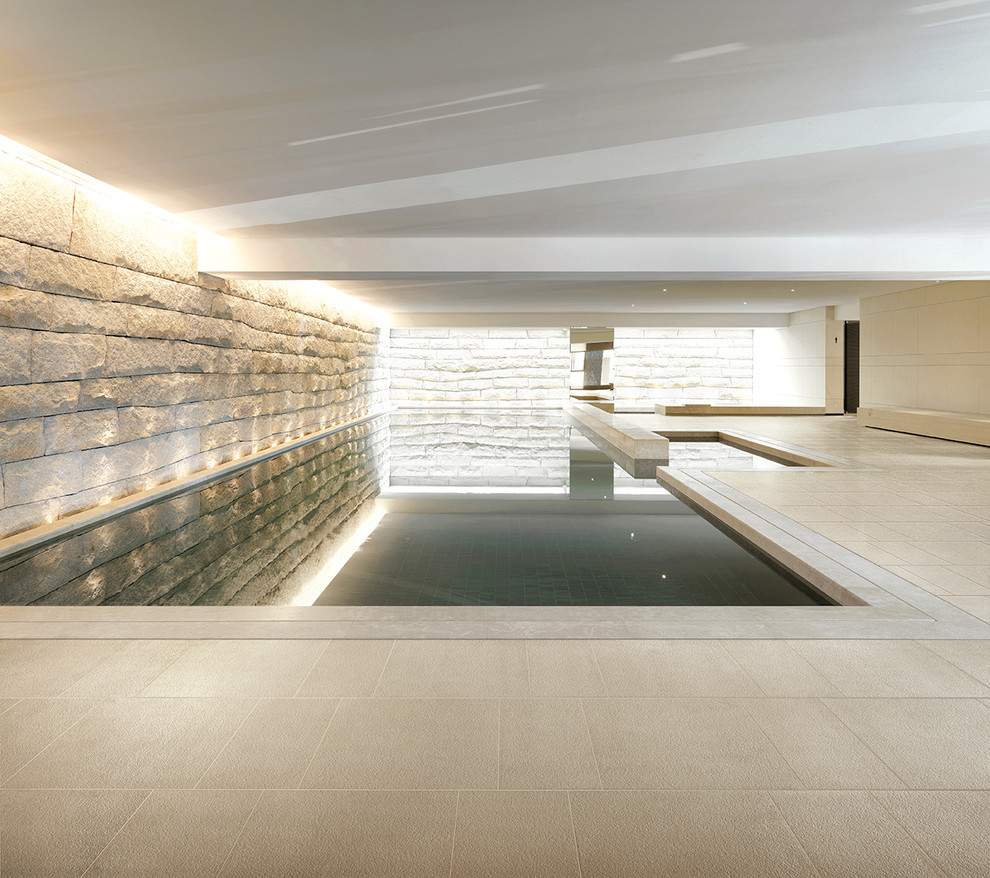 На фото: прямоугольный бассейн в доме в современном стиле с покрытием из плитки