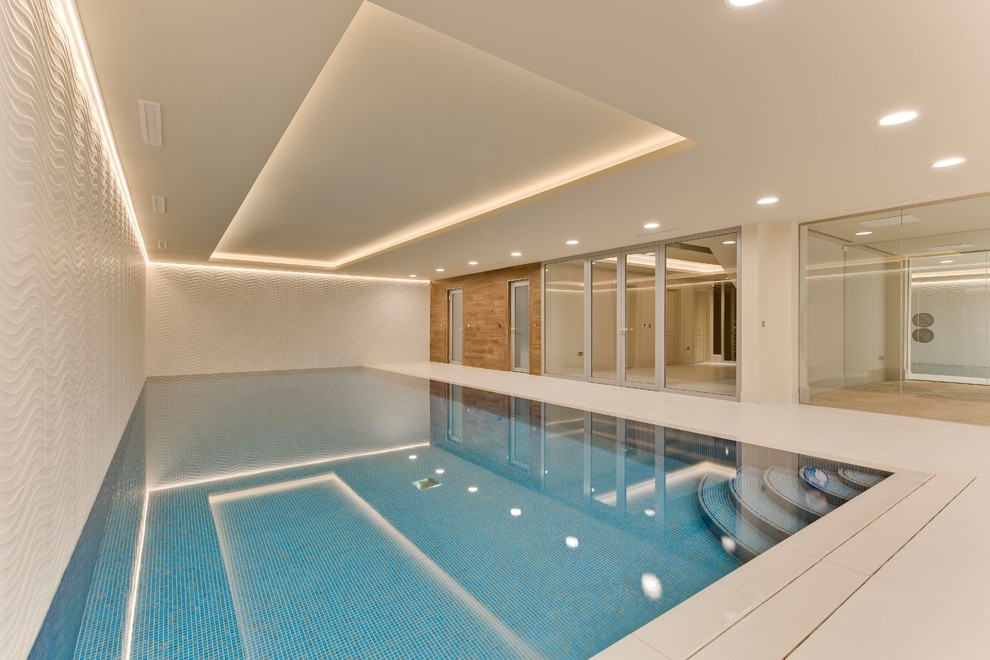 На фото: большой прямоугольный, спортивный бассейн в доме в современном стиле с покрытием из плитки с