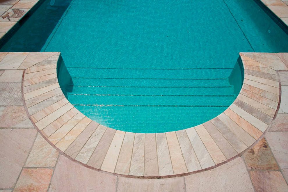 Imagen de piscina natural de estilo de casa de campo de tamaño medio rectangular en patio trasero con suelo de baldosas