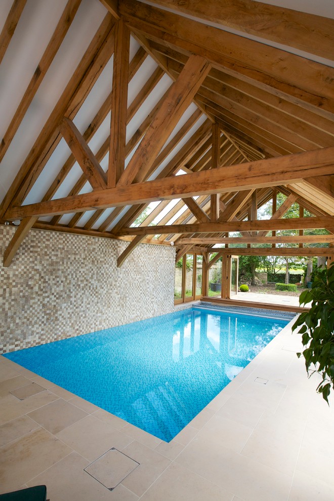 Bild på en mycket stor lantlig rektangulär, inomhus pool, med naturstensplattor