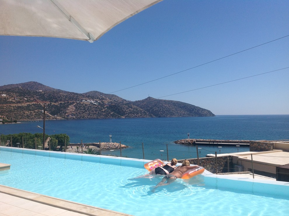 Idee per una piscina a sfioro infinito mediterranea personalizzata di medie dimensioni e davanti casa con piastrelle
