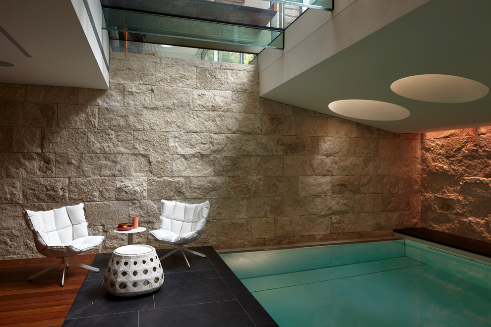 Cette image montre une petite piscine intérieure design rectangle avec des pavés en pierre naturelle.