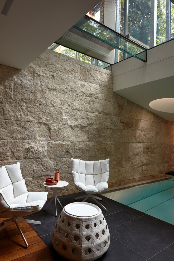 Modelo de piscina contemporánea grande interior y rectangular con adoquines de piedra natural