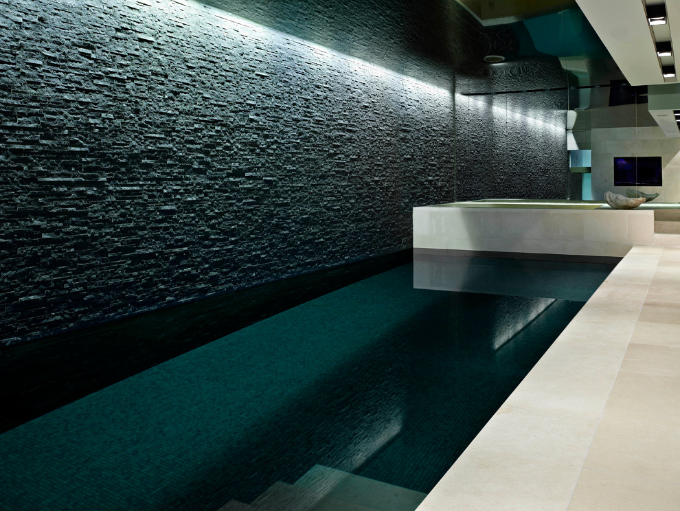 Idée de décoration pour une piscine intérieure design de taille moyenne et rectangle avec des pavés en pierre naturelle.