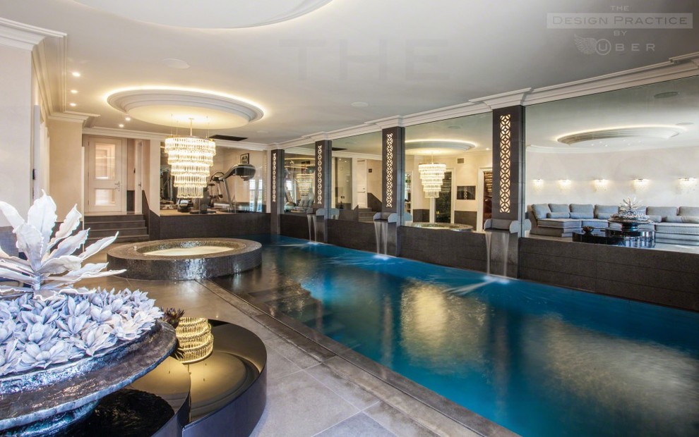 Aménagement d'une très grande piscine intérieure contemporaine rectangle avec une dalle de béton et un bain bouillonnant.